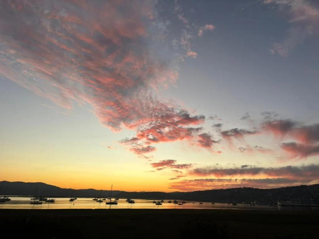 Stunning sunset over Knysna Heads with moored boats and mountains