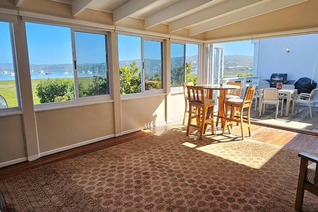 Expansive windows frame scenic lagoon and mountain views from bright interior space