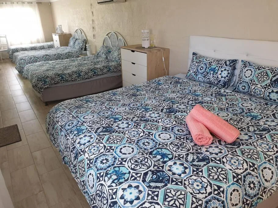 Spacious bedroom with three beds and blue patterned bedding
