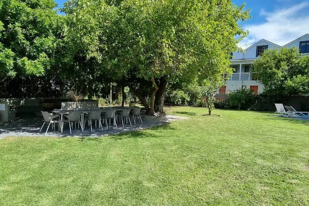 Outdoor dining area with table and chairs beneath mature tree