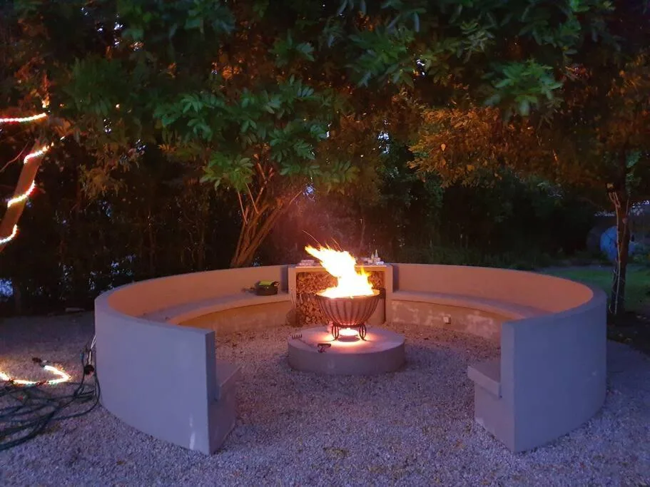 Evening fire pit with curved white seating and burning flames outdoors