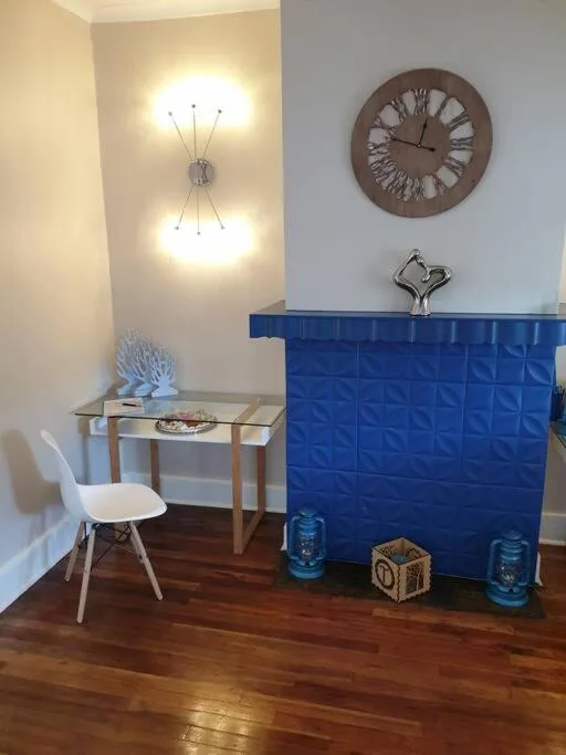 Modern entryway with decorative clock, elegant lighting, and glass desk
