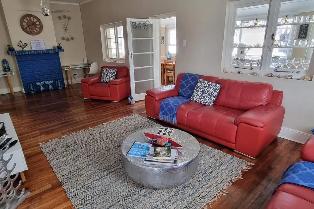 Spacious living room with red leather sofas and blue accent pillows