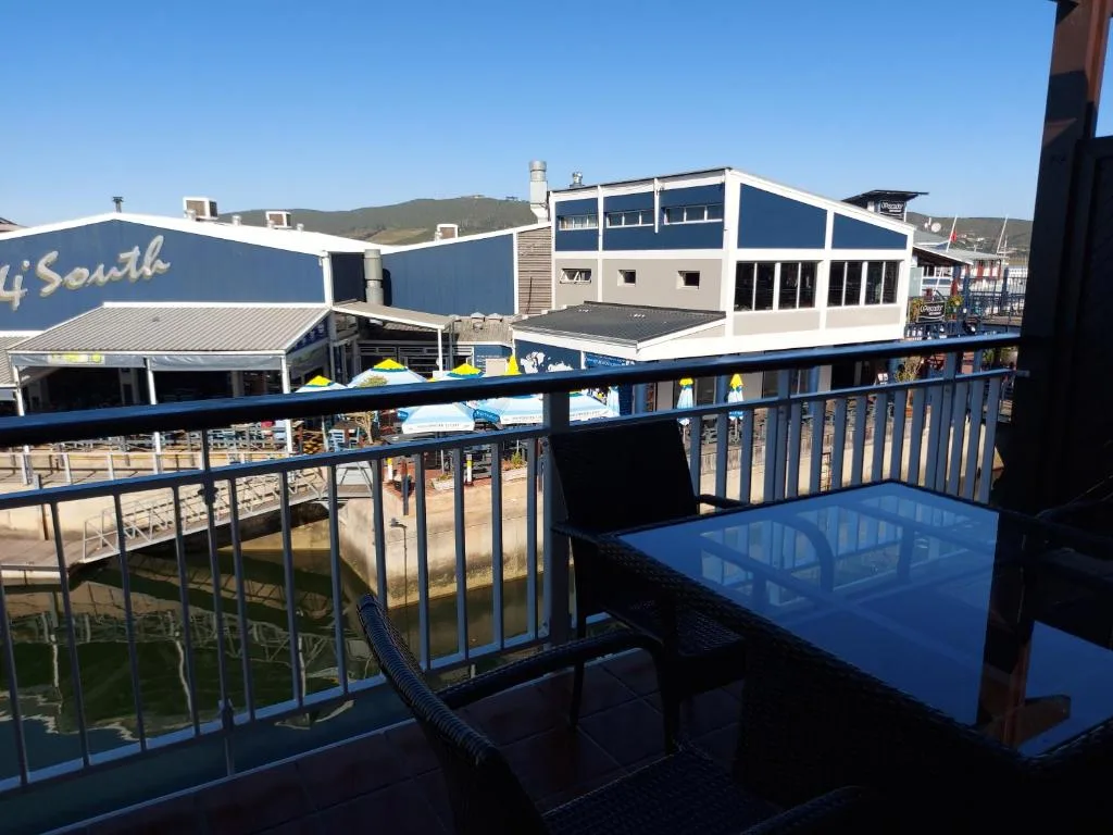 Blue balcony overlooking Knysna Quays with waterfront buildings and mountains