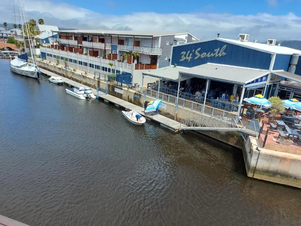Waterfront apartment building with blue signage overlooking Knysna lagoon
