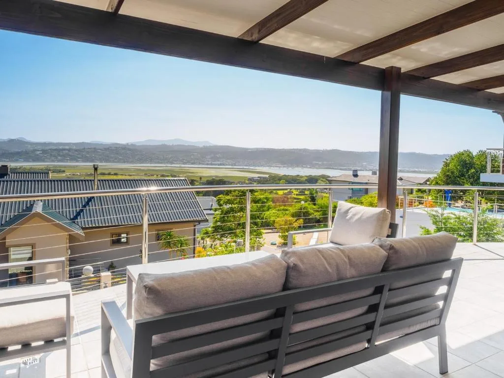Covered deck with outdoor seating overlooking lagoon and mountains