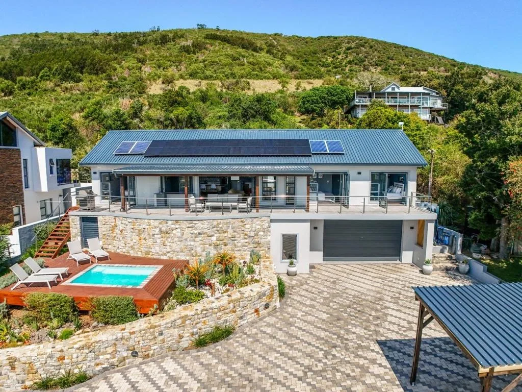 Modern white house with pool, solar panels, and mountain views in Knysna