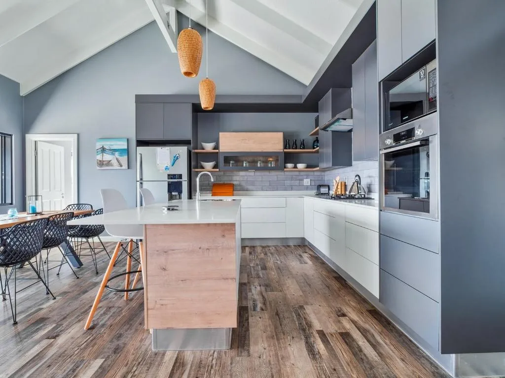 Modern kitchen with white cabinetry, island bench, and woven pendant lights