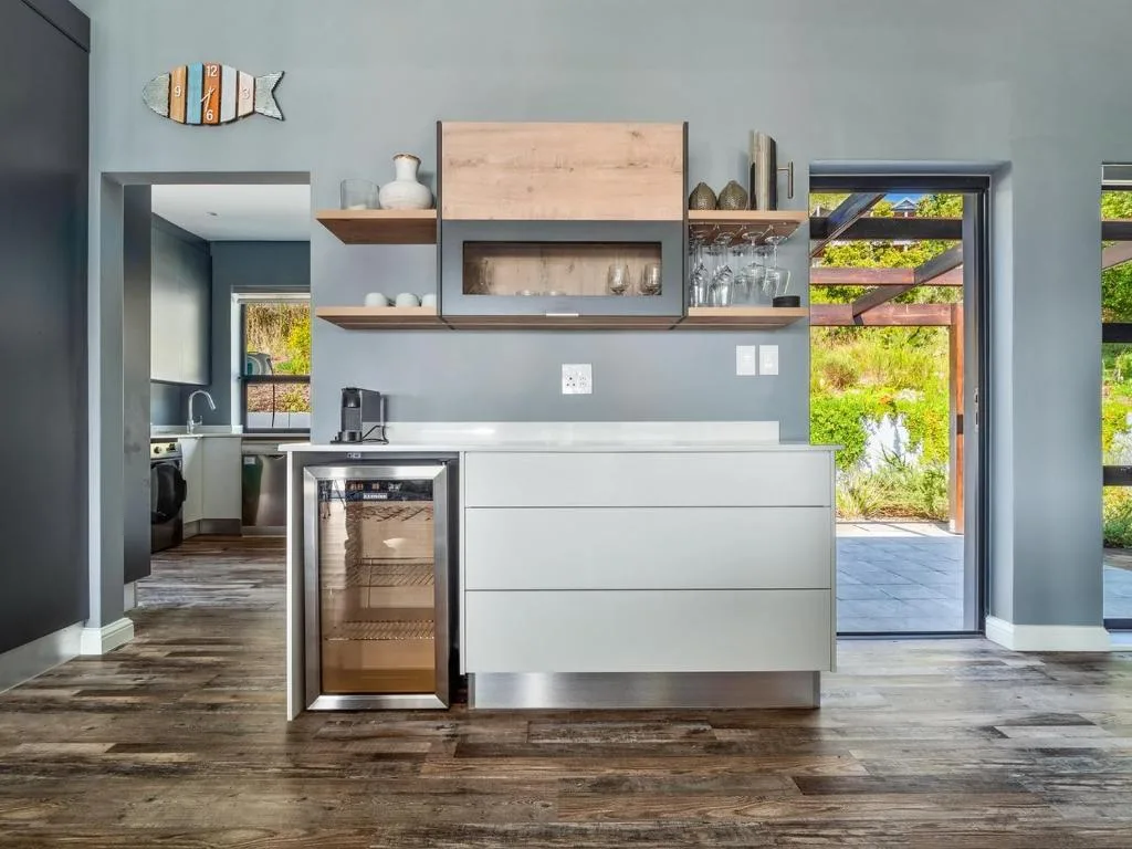 Modern kitchen with white cabinetry, stainless steel appliances, and open shelving