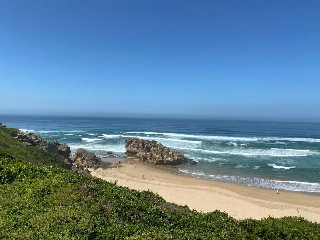 Scenic coastal beach with rocky outcrops and turquoise ocean waves