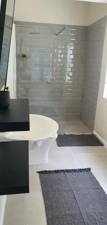 Modern bathroom with glass-enclosed shower and white toilet fixture