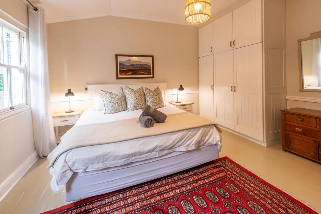 Spacious bedroom with queen bed, built-in wardrobes, and natural light