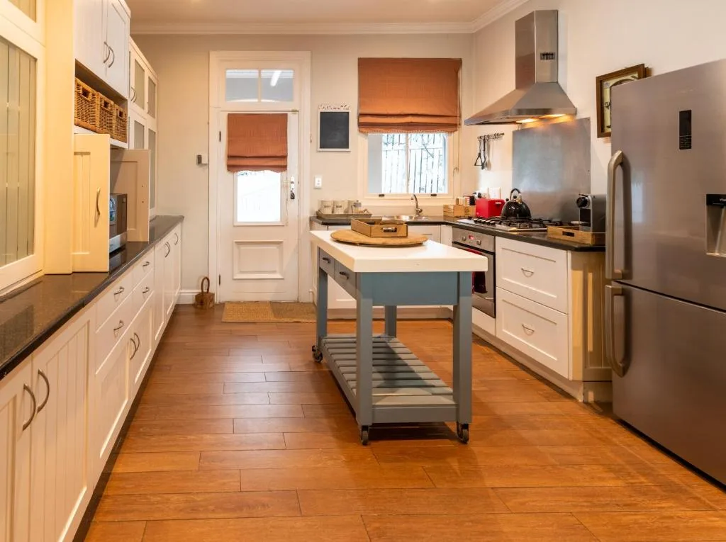 Modern kitchen with island, stainless steel appliances, white cabinetry