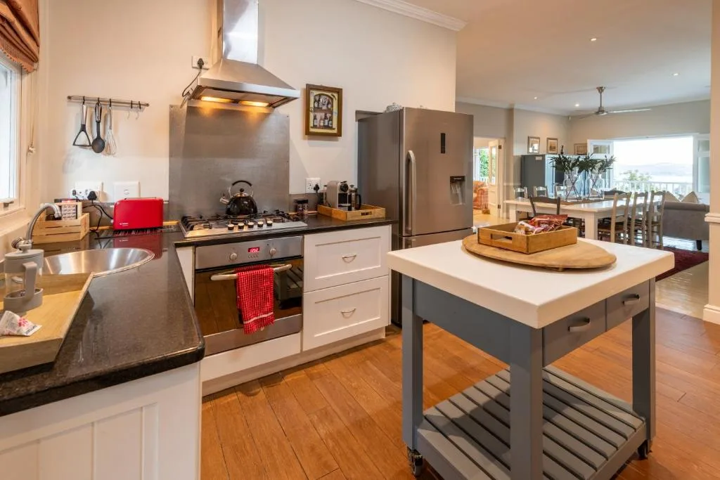 Modern kitchen with stainless steel appliances, island bench, and open-plan living area