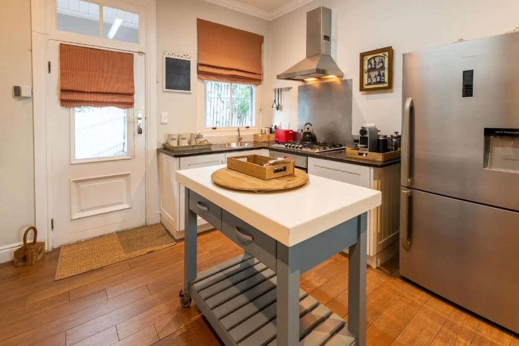 Modern kitchen with island counter, stainless steel appliances, and natural light