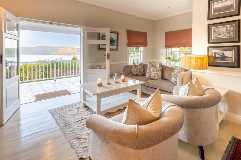 Elegant lounge with comfortable seating and panoramic lagoon views through open doors