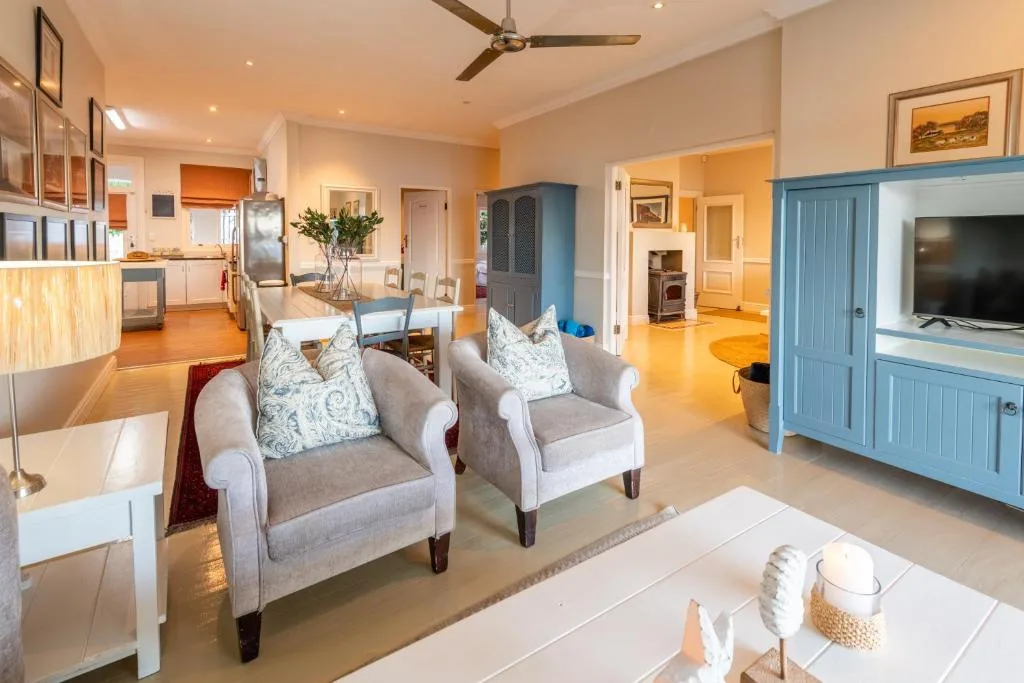 Spacious lounge with comfortable seating, ceiling fan, and open-plan layout