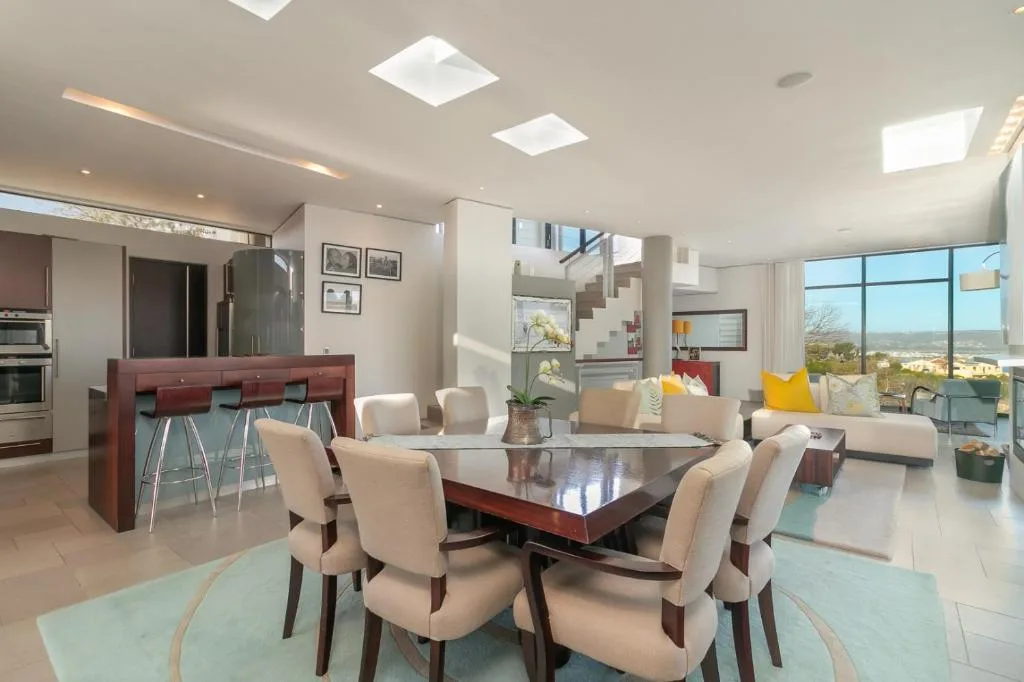 Modern dining area with dark wood table and cream upholstered chairs