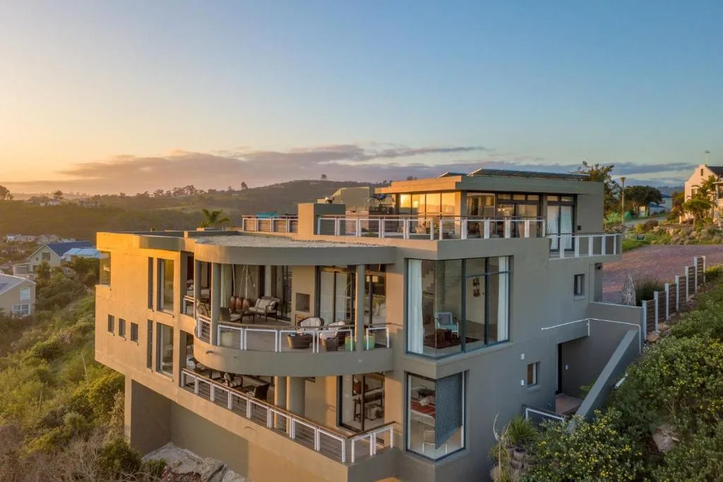 Modern multi-story villa with expansive decks overlooking lush Garden Route landscape