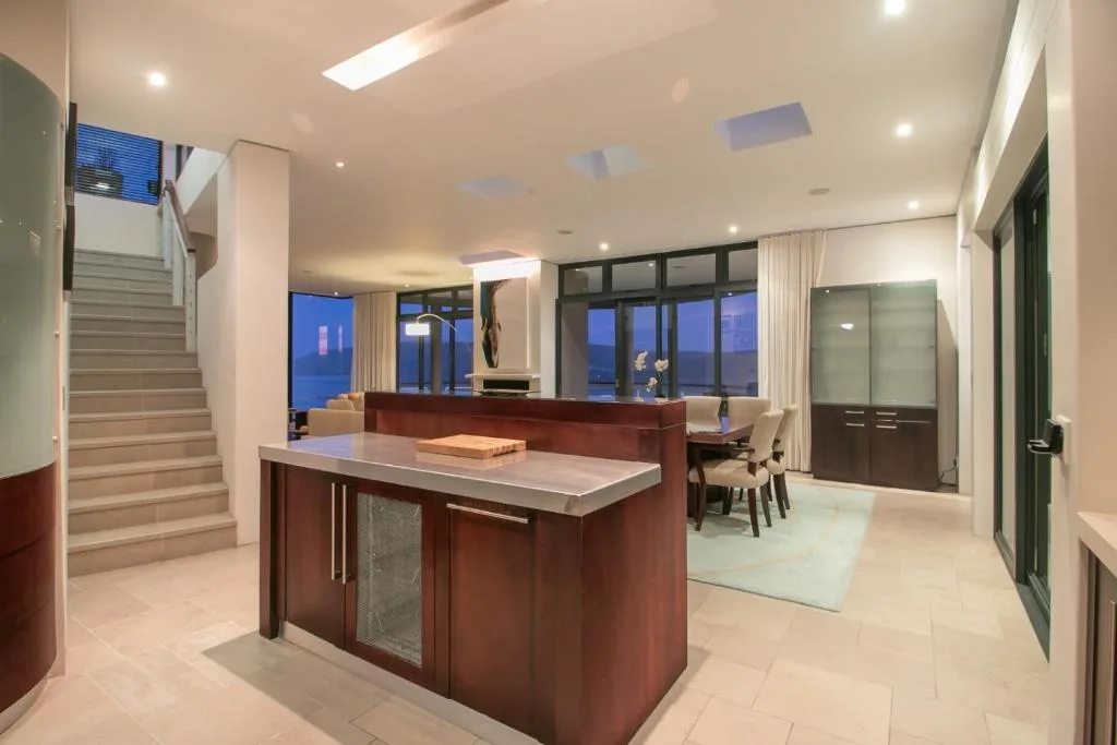 Modern open-plan kitchen with dark wood island and stainless steel countertop