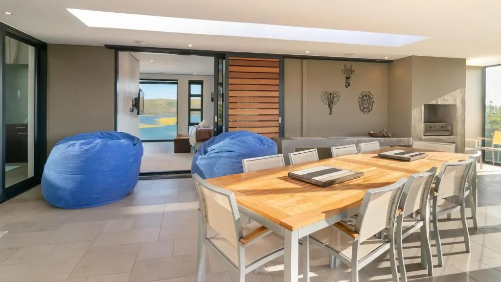 Open-plan living area with dining table, blue bean bags, and ocean views