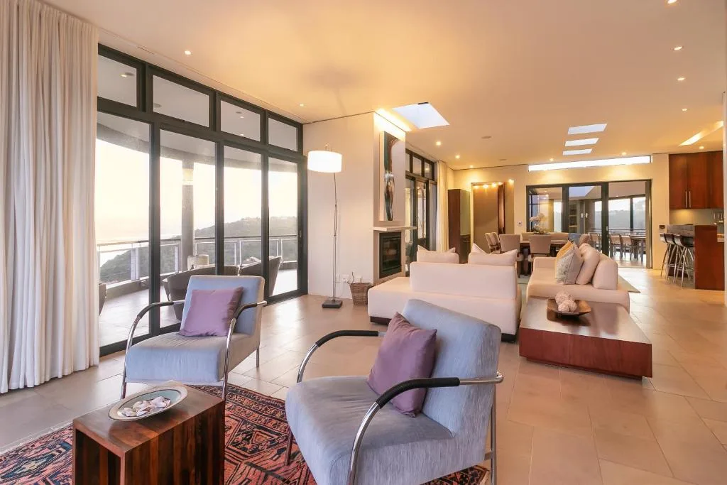 Spacious lounge with comfortable seating and panoramic window views overlooking mountains
