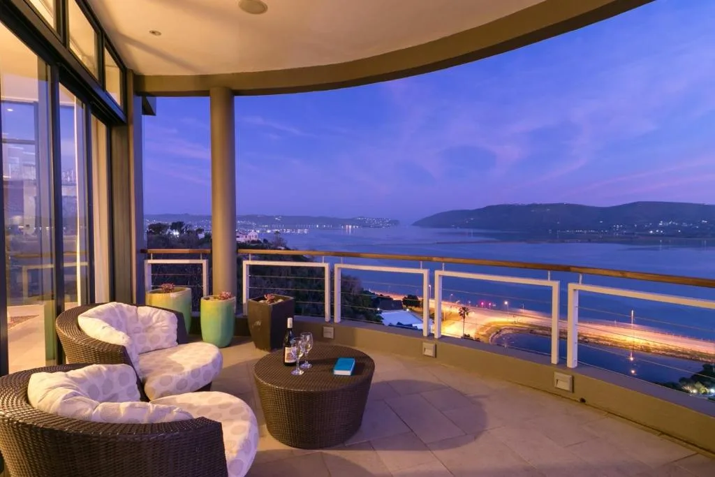 Twilight lagoon and mountain vista from expansive deck with coastal lights
