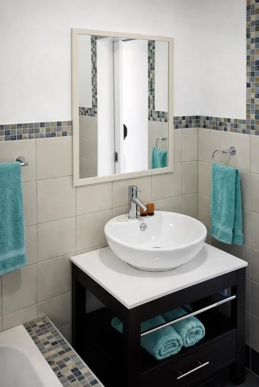 Modern bathroom with round white basin sink and mirrored cabinet