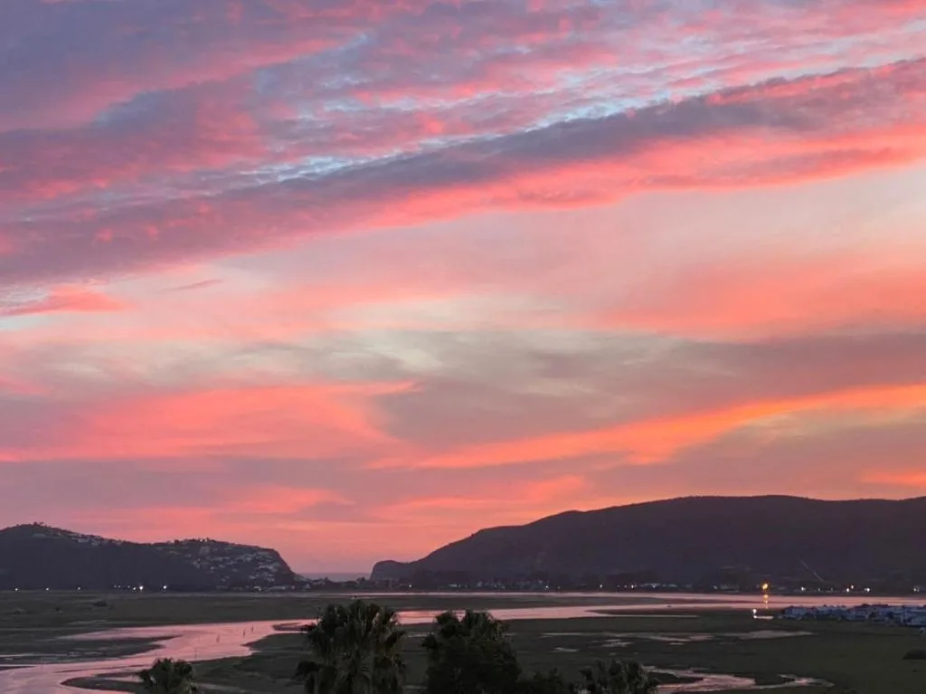 Stunning sunset over Knysna Lagoon with dramatic pink and orange sky
