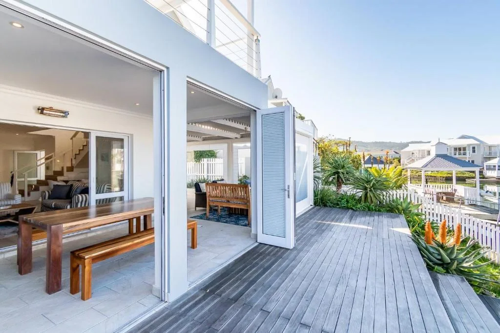 Spacious wooden deck with garden views and indoor-outdoor dining access