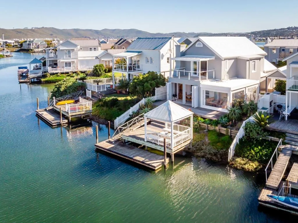 Waterfront property with white exterior, private dock, and lagoon views