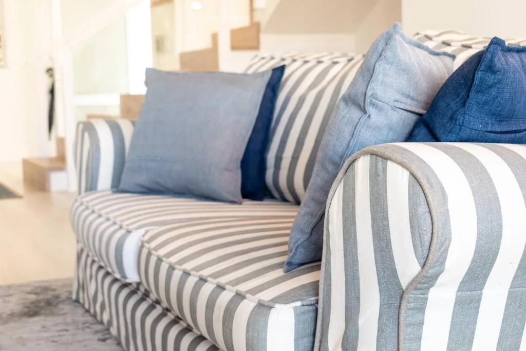Striped upholstered sofa with blue and grey cushions in bright living room