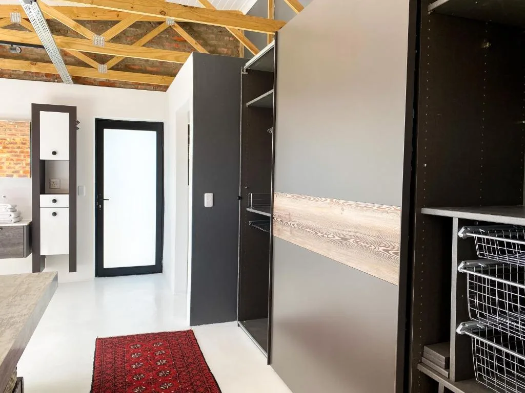 Modern bathroom with walk-in shower, exposed wooden beams, and contemporary finishes