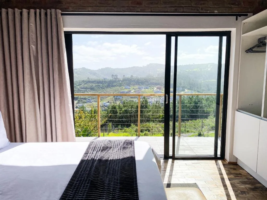 Bright bedroom with mountain and valley views through modern glass doors