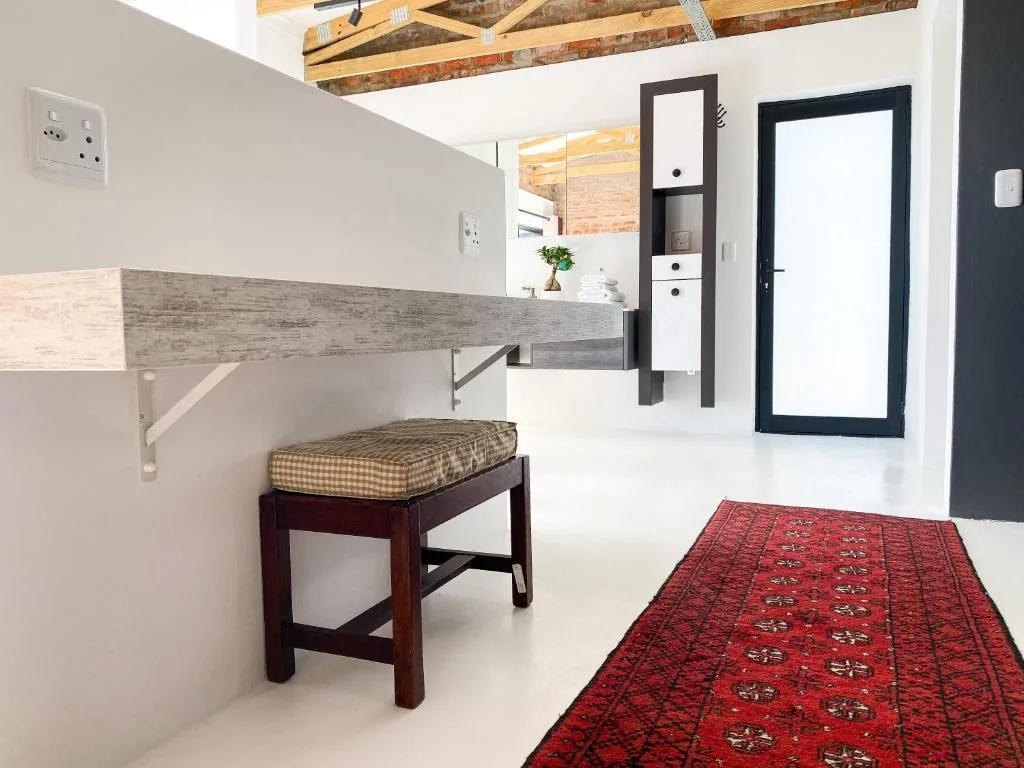 Modern interior hallway with wooden bench seating and red runner rug