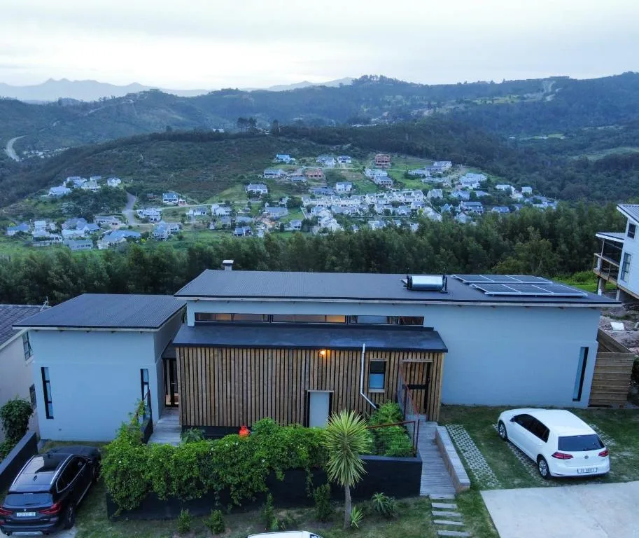 Modern white house with metal roof overlooking Knysna valley and surrounding hills