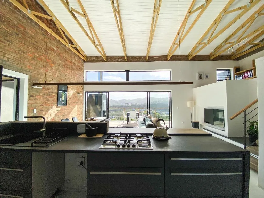 Modern kitchen with gas cooktop, dark counters, skylight, and scenic valley views