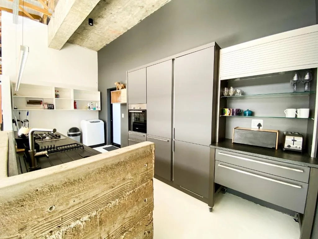Modern kitchen with gas cooktop, built-in oven, and gray cabinetry