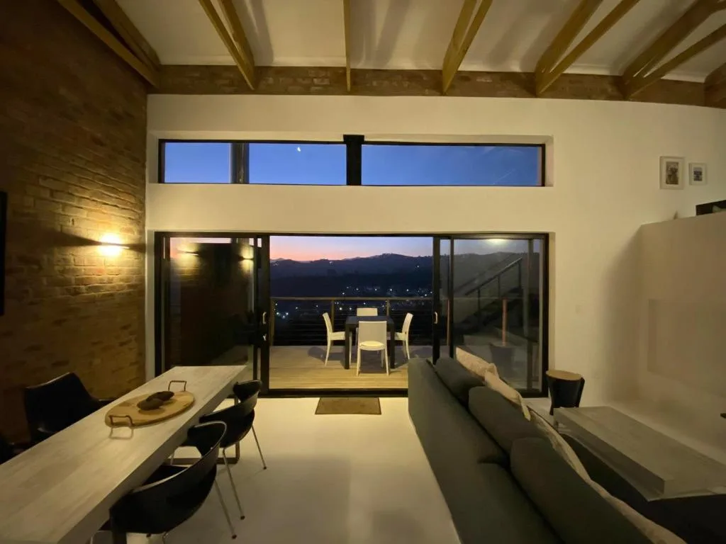Modern lounge with sofa opening to deck and mountain views at dusk