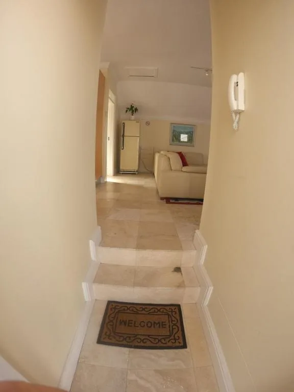 Welcoming entrance hallway with welcome mat and stairs leading to open-plan living area
