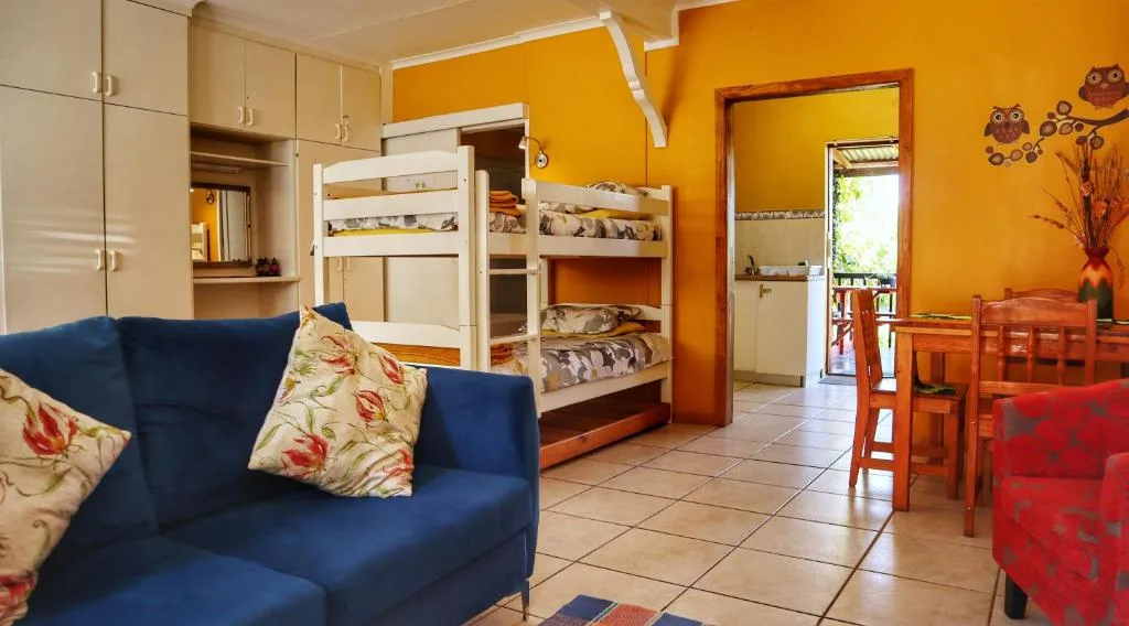 Bright bedroom with bunk beds, blue sofa, and yellow accent walls