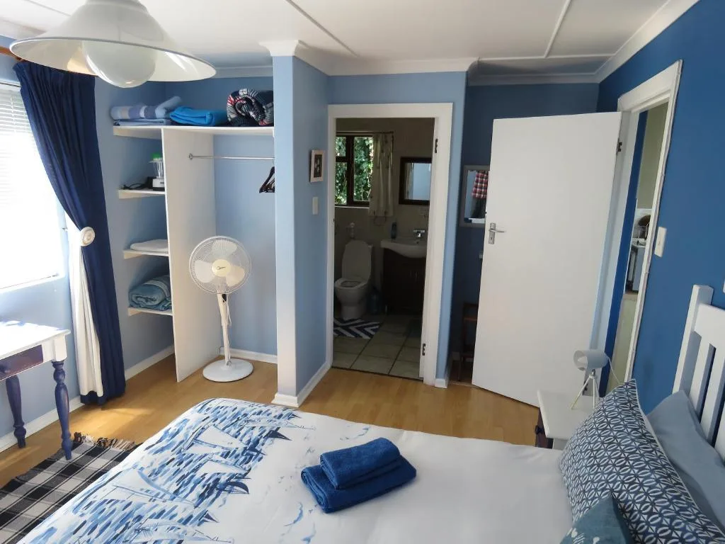 Bright blue bedroom with queen bed, built-in wardrobes, and en-suite bathroom