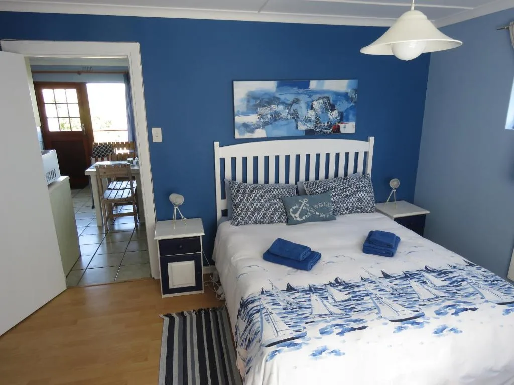 Bright blue bedroom with white bed frame and nautical-themed decor