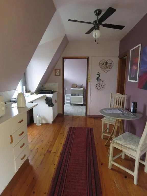 Attic bedroom with sloped ceiling, desk, and natural light from window