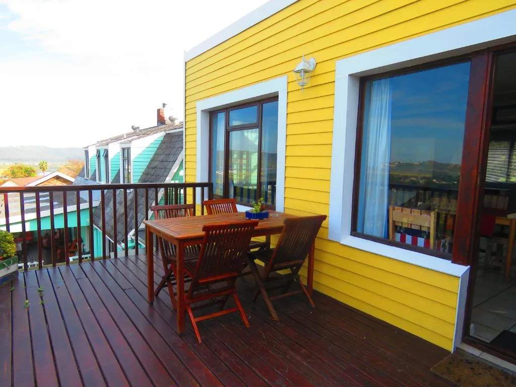 Wooden deck with dining table overlooking Knysna mountains and lagoon