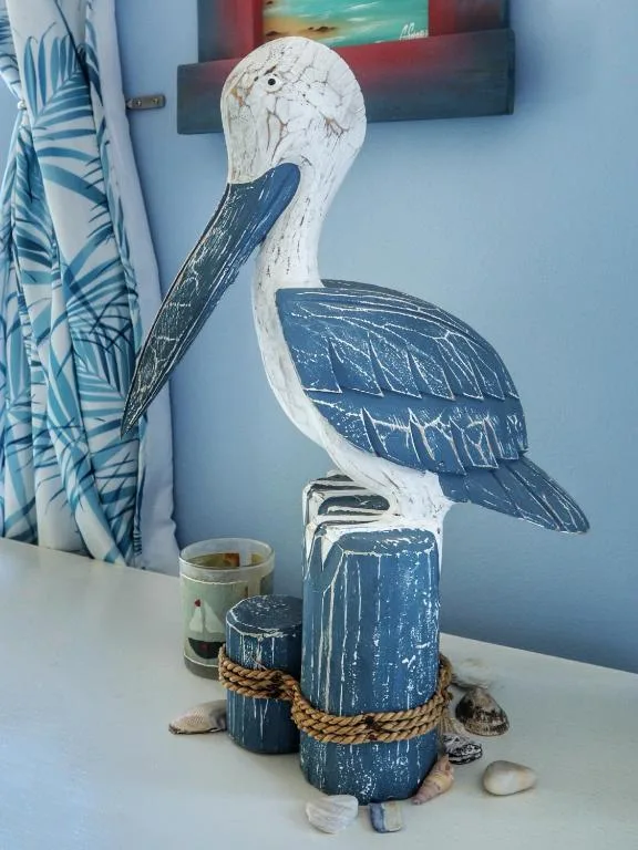 Coastal-themed wooden pelican sculpture with nautical rope and shells decoration