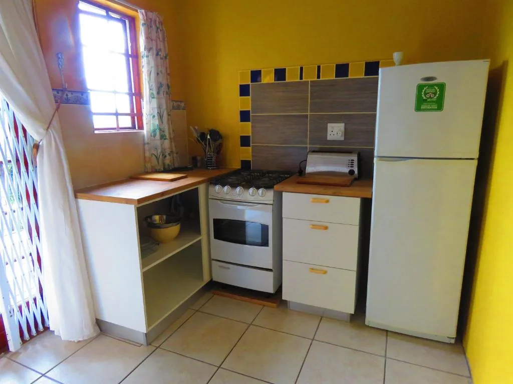 Bright yellow kitchen with stove, refrigerator, and wooden countertops