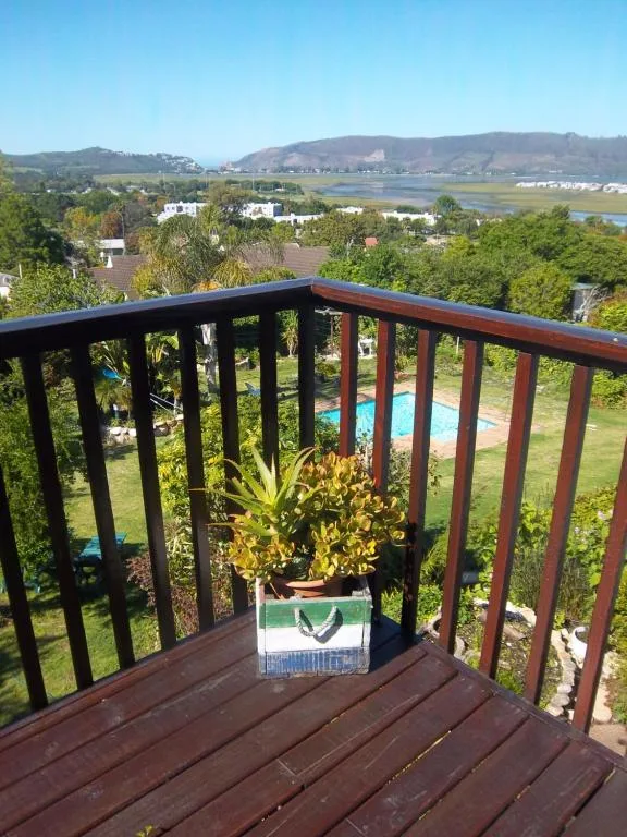 Scenic lagoon and mountain vista from elevated deck with potted plant