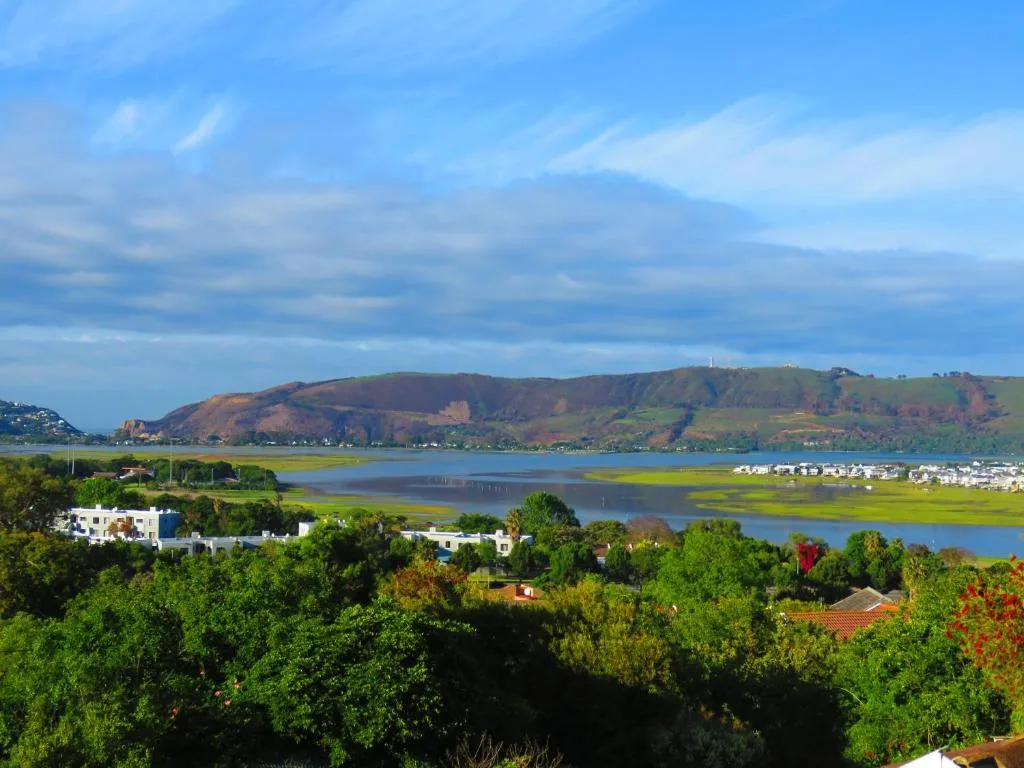 Lagoon view with green hills, white buildings, and blue sky