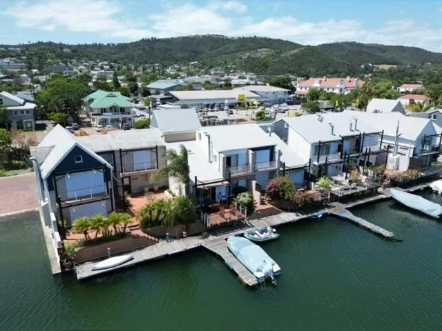 Modern waterfront apartment complex with white facades and boat docks